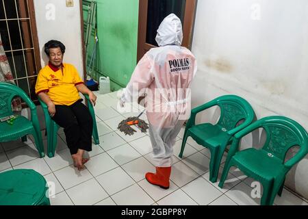 Bogor, Indonesien. August 2021. Nurhasanah wischt den Boden des Hauses.Nurhasanah (37) ein Mitglied der Freiwilligen Polisi Masyarakat kümmert sich um einen behinderten Patienten, der verdächtigt wird, bei Covid-19 unter Selbstisolierung zu sein. Lapor Covid-19, eine Koalition der Zivilgesellschaft, die Informationen über Coronaviren im ganzen Land zusammenstellt, berichtete über die Zahl der Covid-19-Todesfälle. (Foto: Wisnu Agung Prasetyo/SOPA IMAG/Sipa USA) Quelle: SIPA USA/Alamy Live News Stockfoto