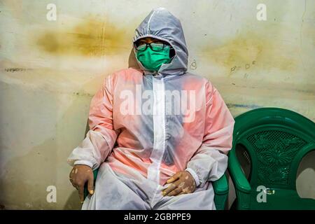 Bogor, Indonesien. August 2021. Nurhasanah macht eine Pause.Nurhasanah (37) ein Mitglied der Freiwilligen Polisi Masyarakat kümmert sich um einen behinderten Patienten, der verdächtigt wird, bei Covid-19 in Isolation zu sein. Lapor Covid-19, eine Koalition der Zivilgesellschaft, die Informationen über Coronaviren im ganzen Land zusammenstellt, berichtete über die Zahl der Covid-19-Todesfälle. (Foto: Wisnu Agung Prasetyo/SOPA IMAG/Sipa USA) Quelle: SIPA USA/Alamy Live News Stockfoto