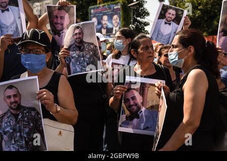 Beirut, Libanon, 4. August 2021. Verwandte von Menschen, die von der Beirut Blast getötet wurden, bereiten sich auf den marsch zum Hafen von Beirut mit Bildern ihrer ermordeten Angehörigen zum einjährigen Jahrestag der großen Explosion vor. Stockfoto