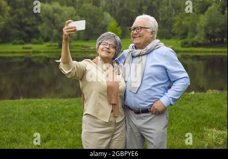 Glückliche reife Frau steht und macht Selfie-Porträt mit Ehemann auf Handy Stockfoto