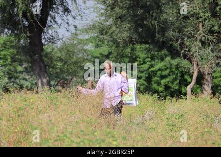 Nahaufnahme eines indischen älteren hindu-Mannes, der eine Tasche in der Hand hält, führt durch die Büsche im Wald. Stockfoto