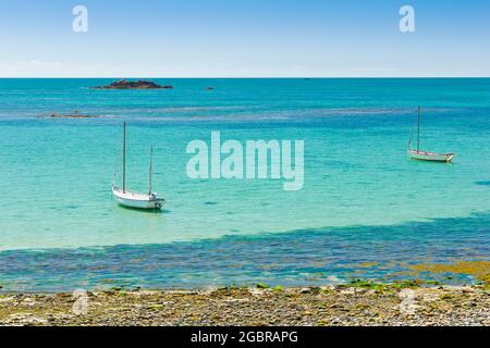 Zwei weiße Fischerboote in der Bucht in der Nähe des Le Hocq Tower am Südufer von Jersey, Channel Islands, Großbritannien, an einem sonnigen Sommertag. Stockfoto