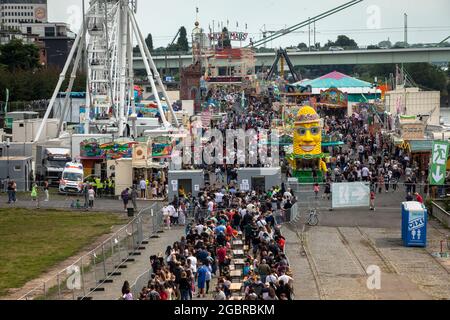 Leute, die in der Schlange stehen, Corona-konform, um den Jahrmarkt, den temporären Vergnügungspark Happy Colonia, am Ufer des Rheins in Deutz, C, zu betreten Stockfoto