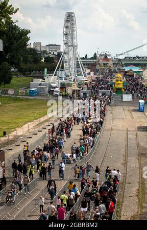 Leute, die in der Schlange stehen, Corona-konform, um den Jahrmarkt, den temporären Vergnügungspark Happy Colonia, am Ufer des Rheins in Deutz, C, zu betreten Stockfoto
