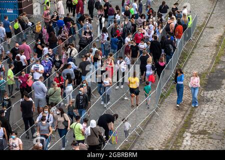 Leute, die in der Schlange stehen, Corona-konform, um den Jahrmarkt, den temporären Vergnügungspark Happy Colonia, am Ufer des Rheins in Deutz, C, zu betreten Stockfoto