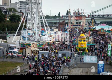 Leute, die in der Schlange stehen, Corona-konform, um den Jahrmarkt, den temporären Vergnügungspark Happy Colonia, am Ufer des Rheins in Deutz, C, zu betreten Stockfoto