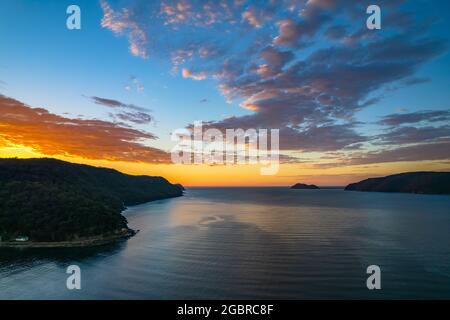 Fischerboote und Sonnenaufgang in Brisk Bay vom Patonga Beach an der Central Coast von NSW, Australien. Stockfoto