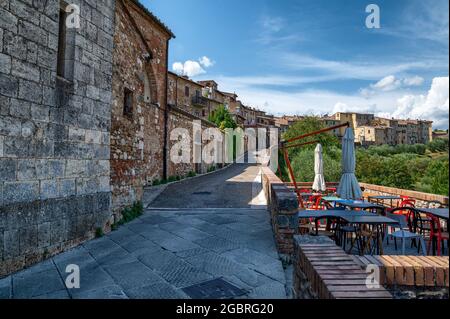 Colle di Val d'Elsa, Toskana, Italien. August 2020. Erstaunliche Stadtlandschaft entlang der Außenmauern des historischen Zentrums. Auf der rechten Seite die Tische eines BA Stockfoto