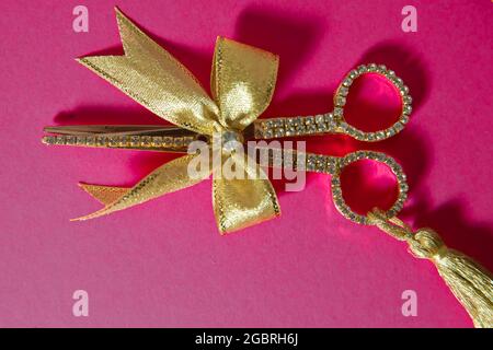 Rosa Band auf Gold Schere Rosa Hintergrund. Gold Schere rosa flach legen minimalen Hintergrund Stockfoto