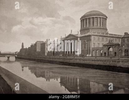 Eine Ansicht der vier Gerichte aus dem späten 19. Jahrhundert spiegelte sich im Fluss Liffey wider. Das Gebäude ist Irlands prominentestes Gerichtsgebäude, das sich am Inns Quay in Dublin befindet und der Hauptsitz des Obersten Gerichtshofs, des Berufungsgerichts, des Obersten Gerichtshofs und des Dubliner Amtsgerichts ist. Es basierte auf dem Entwurf von Thomas Cooley für das Public Records Office of Ireland, aber nach seinem Tod im Jahr 1784 wurde der renommierte Architekt James Gandon mit der Fertigstellung des Gebäudes beauftragt. Zwischen 1786 und 1796 erbaut, wurden die Arkaden und Flügel 1802 fertiggestellt. Stockfoto