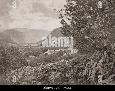 Ein Blick aus dem späten 19. Jahrhundert auf Glendalough, ein Gletschertal in der Grafschaft Wicklow, Irland, das für eine frühmittelalterliche Klostersiedlung bekannt ist, die im 6. Jahrhundert von St. Kevin, einem Nachkommen einer der regierenden Familien in Leinster, gegründet wurde. Der ferne runde Turm, etwa 30 Meter hoch, diente als Wahrzeichen für sich nähernde Besucher, als Glockenturm und gelegentlich als Lagerhaus und Zufluchtsort in Zeiten des Angriffs. Stockfoto