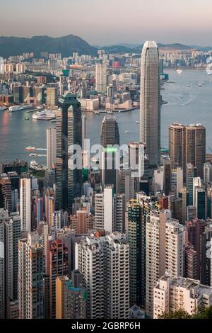 Die Wolkenkratzer und die hochdichte Stadtlandschaft von Mid-Levels und Central auf Hong Kong Island, Kowloon und Victoria Harbour, bei Sonnenuntergang Stockfoto