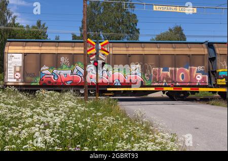 NORTH COUNTY, SCHWEDEN AM 17. JUNI. Ansicht eines Wagens auf einem Bahnübergang am 17. Juni 2021 in Schweden. Graffiti-Malerei. Redaktionell. Stockfoto