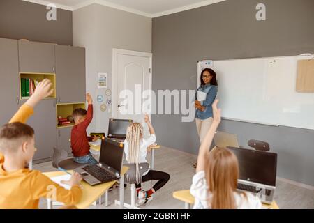 Jungen und Mädchen, die während des Unterrichts im Klassenzimmer sitzen Stockfoto