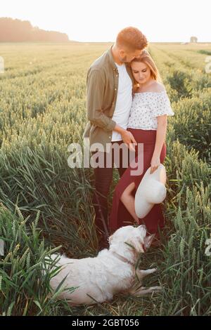 Zeit in der Natur für ein trächtiges Paar zu Fuß mit ihrem Hund. Schwanger Frau . Familie und Schwangerschaft. Liebe und Zärtlichkeit. Glück und Gelassenheit. Nehmen Stockfoto