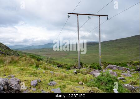 Stromleitungen in den County Kerry Mountains in Irland Stockfoto