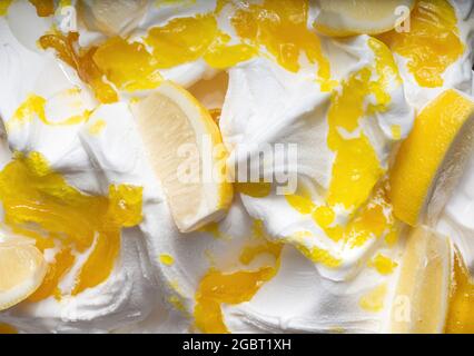 Frozen Lemon Flavour Gelato - Vollformat Detail. Nahaufnahme einer weißen Oberflächenstruktur von Eiscreme, bedeckt mit Stücken gelber Früchte. Stockfoto