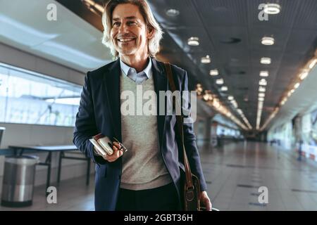 Mann, der mit dem Flugzeug reist. Männlicher Passagier, der durch den Flughafendurchgang zum Flugsteig geht. Stockfoto