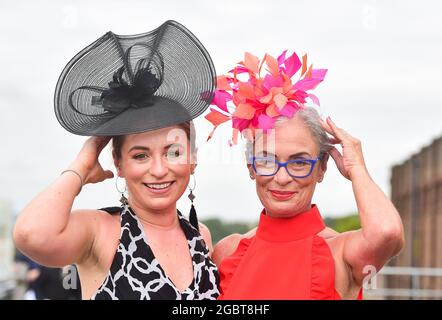 Brighton UK 5. August 2021 - Rennfahrer bleiben auf dem Hut, wenn sie an einem luftigen Nachmittag zum Brighton Races Ladies Day kommen : Credit Simon Dack / Alamy Live News Stockfoto