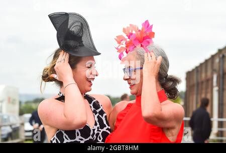 Brighton UK 5. August 2021 - Rennfahrer bleiben auf dem Hut, wenn sie an einem luftigen Nachmittag zum Brighton Races Ladies Day kommen : Credit Simon Dack / Alamy Live News Stockfoto