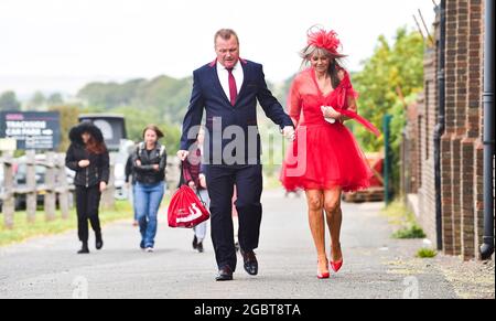 Brighton UK 5. August 2021 - stilvolle Rennfahrer kommen an einem luftigen Nachmittag zum Brighton Races Ladies Day : Credit Simon Dack / Alamy Live News Stockfoto