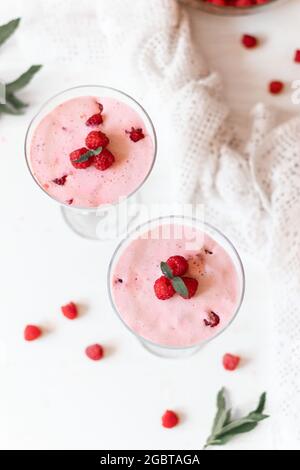 Köstliches Himbeer-Dessert, Käsekuchen, Maus im Glas auf weißem Tischhintergrund. Sommer gesunde Lebensmittel Stockfoto