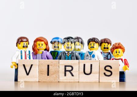 Gruppe von verängstigten Menschen mit hölzernen „Virus“-Zeichen. Illustratives Editorial. 18. Juli 2021 Stockfoto