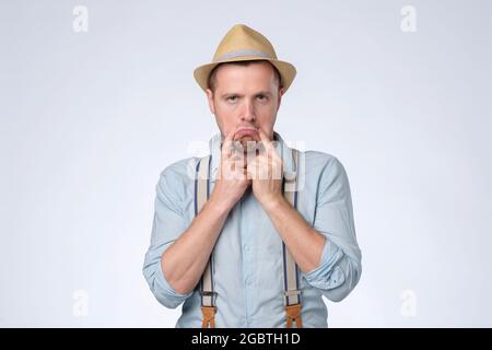Besorgter kaukasischer Mann, der schlechte Laune hatte und ein trauriges Lächeln zeigte. Stockfoto