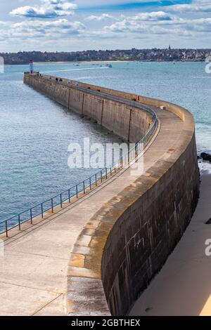 Ein steinerner Wellenbrecher und ein Leuchtturm im Hafen von Saint Malo. Frankreich. Bretagne. Stockfoto