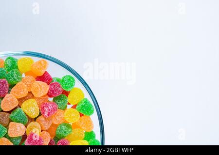 Bunte Gelee-Zucker-Bonbons in der Schale isoliert auf weißem Hintergrund mit Kopierraum. Leckere Marmeladen in der Schüssel. Stockfoto