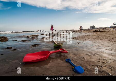 Überfüllter, farbenfroher Strand mit Menschen, Sonnenschirmen und Sonnenliegen, Sommerferien und Tourismuskonzept Stockfoto