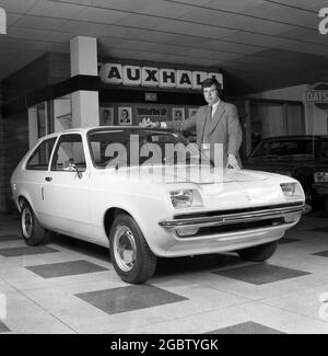 1975, historisch, ein Autoverkäufer, der neben einem kleinen Vauxhall-Heckwagen in einem Showroom steht, Croydon, England, Großbritannien. Stockfoto