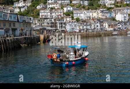 Looe, Cornwall, England, Großbritannien. 2021. Fischerboot bei ankommender Flut mit einem Hintergrund des malerischen West Looe a Resorts in Cornwall, Großbritannien. Stockfoto