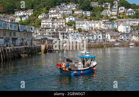 Looe, Cornwall, England, Großbritannien. 2021. Fischerboot bei ankommender Flut mit einem Hintergrund des malerischen West Looe a Resorts in Cornwall, Großbritannien. Stockfoto