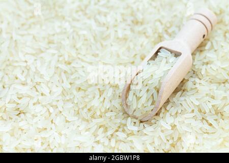 Holzlöffel roher weißer Bio-Reis, Zutat zum Kochen asiatischer Lebensmittel Stockfoto