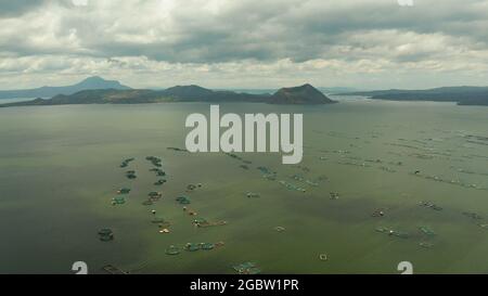 Lake Taal mit einem Vulkan und Fischkäfigen auf einer Fischfarm Blick von oben. Luzon, Philippinen tropische Landschaft, Berge und Vulkan im See. Stockfoto