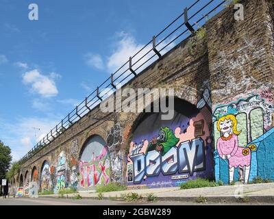 Graffiti bedeckt ein viktorianisches Eisenbahnviadukt aus Backstein in Deptford, Südost-London, UK.i. Stockfoto