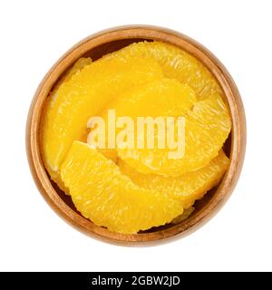 Orange Scheiben überragend, in einer Holzschale. Frische, reife Orangensegmente, ohne Membranen geschnitten, süße Frucht mit saftigem, gelbem Fruchtfleisch. Stockfoto