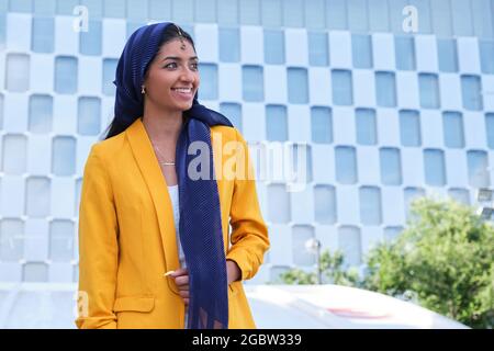 Porträt einer jungen indischen Geschäftsfrau, die im Freien lächelt. Stockfoto