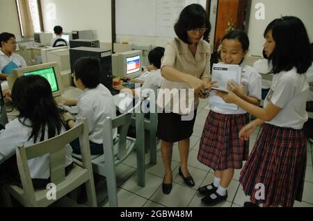 Eine Lehrerin erklärt ihren Schülern in einem Computerraum einige Anweisungen. Stockfoto