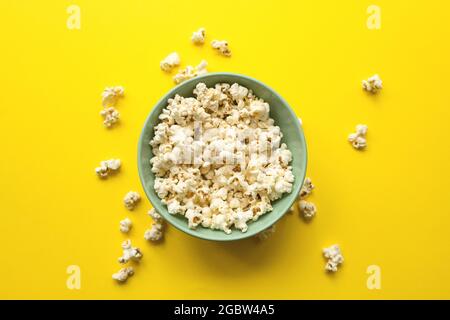 Leckeres Popcorn in der Schüssel und auf gelbem Hintergrund in Nahaufnahme. Food und Snack-Konzept. Stockfoto