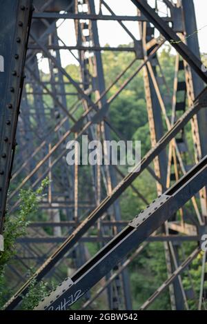 LYNCHBURG, USA - 23. Jul 2021: Eine vertikale Aufnahme eines alten, schwarzen und rosteisernen Zugsteigs in der Nähe des Blackwater Creek Wanderweges in Lynchburg, Stockfoto