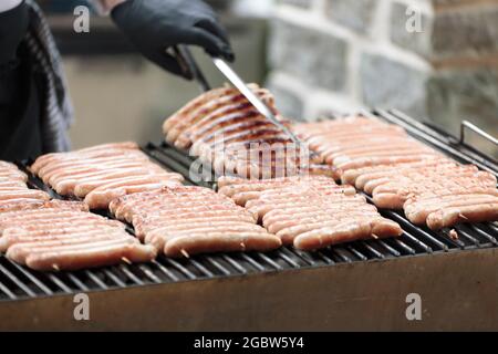 Grill mit belgischen Würstchen Kochen auf dem Grill. Aufnahmen mit natürlichem Licht und selektivem Fokus. Stockfoto