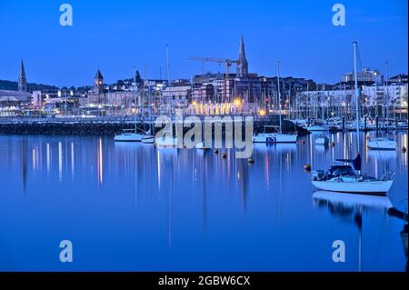 Wunderschöne Aussicht am frühen Morgen auf Boote und Yachten im West Pier des berühmten Hafens von Dun Laoghaire während der blauen Stunde vor Sonnenaufgang, Dublin, Irland Stockfoto