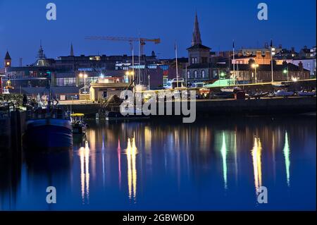 Wunderschöne Aussicht am frühen Morgen auf Boote und Yachten im West Pier des berühmten Hafens von Dun Laoghaire während der blauen Stunde vor Sonnenaufgang, Dublin, Irland Stockfoto