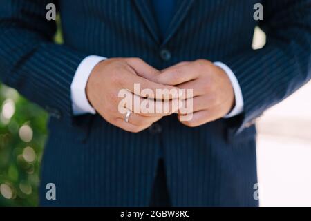 Hände des Bräutigams in einem Anzug mit einem Ring am Finger Stockfoto