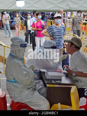 Yantai, Chinas Provinz Shandong. August 2021. Ein Arzt nimmt eine Abstrichprobe für einen COVID-19-Test an einer Teststelle im Bezirk Laishan in Yantai, ostchinesische Provinz Shandong, 5. August 2021. Yantai hat die zweite Runde von Nukleinsäuretests in der ganzen Stadt auf mögliche COVID-19-Fälle oder asymptomatische Infektionen gestartet. Quelle: Tang Ke/Xinhua/Alamy Live News Stockfoto