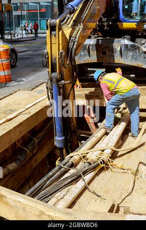 19 APRYL 2019 NY. USA Reparatur der Stadtkommunikation Rohrleitung Installation Bagger grub einen Graben für den Austausch von alten Rohren. Stockfoto