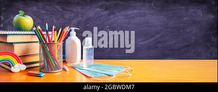 Back To School - Schreibwaren Mit Covid-19 Schutzmaske Und Desinfektionsmittel Stockfoto