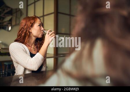 Junge Frau trinkt Wein in der Bar Stockfoto